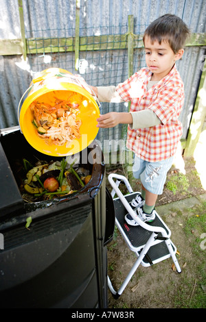 Kind stellt Küchenabfälle in eine Biotonne Stockfoto