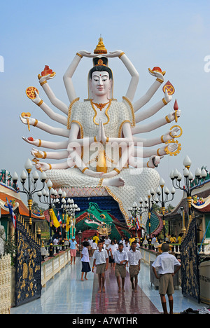 Besucher auf den riesigen Multi bewaffnet geschnitzte Statue einer buddhistischen Gottheit am Wat Nuan Naram Stockfoto