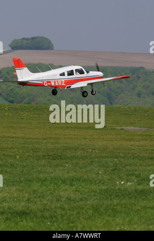 Piper Pa-28-Cherokee Basisflug Trainer landet auf einem Rasen-Flugplatz Stockfoto