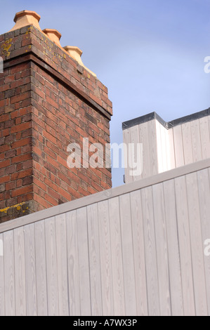 EIN ZEITGENÖSSISCHES GEOMETRISCHE ZUHAUSE MIT HOLZ VERKLEIDUNG NEBEN EINER BENACHBARTEN VIKTORIANISCHE BACKSTEIN STRUKTUR EXETER UK Stockfoto