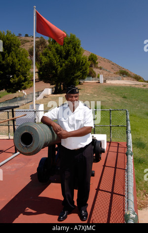 Chief Petty Officer Dudley Malgas posiert neben Mittag Gewehr Kanone in Kapstadt. Stockfoto