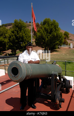 Chief Petty Officer Dudley Malgas posiert neben Mittag Gewehr Kanone in Kapstadt. Stockfoto