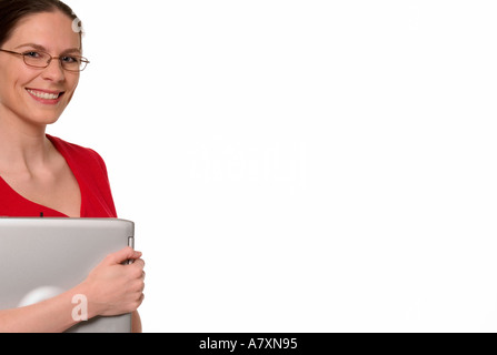 Lächelnde Frau mit roten Kleid und Gläser hält Laptop Computer USA Stockfoto