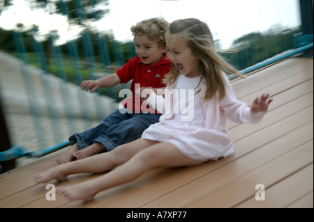 KINDER AUF DER RUTSCHBAHN Stockfoto
