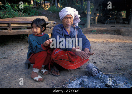 Thailand, Doi Inthanon Nationalpark, ältere Frau und Enkelin sitzen an Wintermorgen in Karen Hill Dorf Feuer Stockfoto