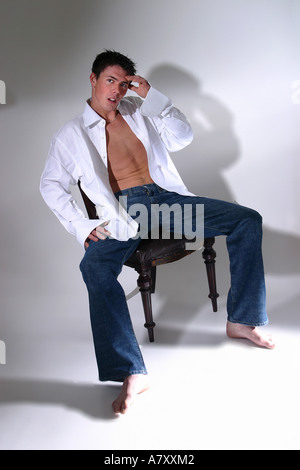 junger Mann Teenager besorgniserregend sorgen Studio weiß blaue Jeans sitzen Forgotton Vergiss nicht müde Müdigkeit untauglich mache Fehler Stockfoto