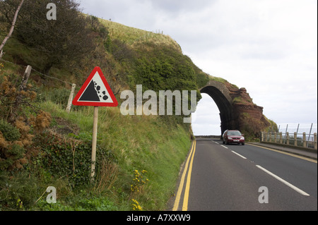 fallende Felsen Roadsign mit Auto in der Straße am roten Bogen Waterfoot Glenariff County Antrim-Nordirland Stockfoto