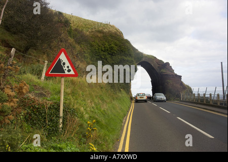 Autos unter roten Bogen bei fallenden Felsen Roadsign Waterfoot Glenariff Grafschaft Antrim Northern Ireland Stockfoto