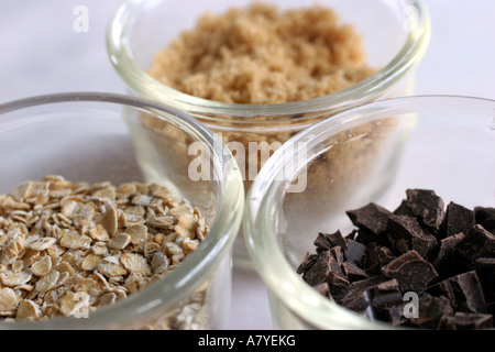 Drei Gläser mit Inhaltsstoffen verwendet um Haferflocken Schokoladenkekse zu machen; Hafer, braunem Zucker und Schokolade Brocken Stockfoto