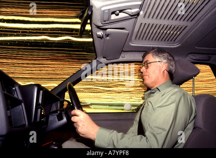 Im Auto in der Nacht Fahrer durch gut beleuchteten Stadtzentrum leichte Spuren von Läden & Straßenlaternen durch Auto windows Essex England Großbritannien Stockfoto