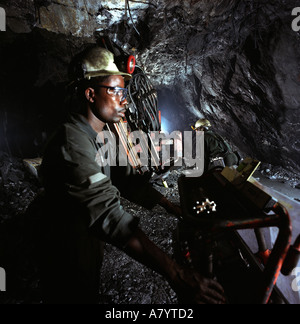 Bergbaubetriebe für den Transport, die Verwaltung und die Verarbeitung von Golderz. Minenarbeiter bohren bei der unterirdischen Goldmine in Ghana nach Gesteinskernproben Stockfoto