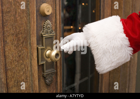 Santa Claus öffnet eine schwere Holztür Stockfoto