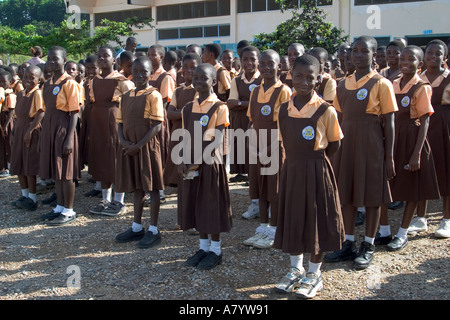 Gemischte Gruppe von jungen Mädchen Schulkinder aufgereiht für die Montage außerhalb Schulgebäude - vor Klassen in Ghana, Westafrika Stockfoto