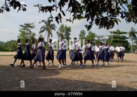 Gemischte Gruppe von älteren Schulmädchen und Jungen Studenten außerhalb marschieren in Versammlung vor Klassen in Ghana, Westafrika Stockfoto