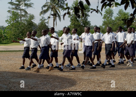 Gruppe von älteren Jungen Studenten in Schuluniformen außerhalb marschieren in die Versammlung vor dem Unterricht in Ghana, Westafrika Stockfoto