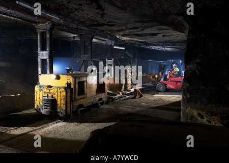 Beladen von ausgegrabenen Steinblöcken mit Gabelstapler auf ein Schmalspurlokomotive Zug in Chilmark unterirdischen Steinbruch Chilmark Wiltshire England Stockfoto