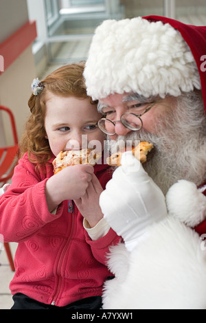 Santa Claus Essen Pizza mit kleinen Mädchen Stockfoto