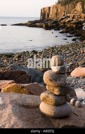 Ein Rock Cairn auf der Kiesstrand im Momument Cove in Maine Acadia National Park.  Otter Klippen sind in der Ferne. Stockfoto