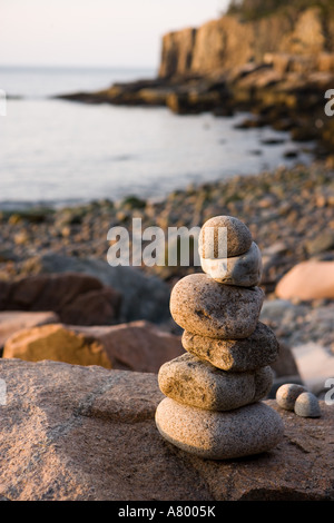 Ein Rock Cairn auf der Kiesstrand im Momument Cove in Maine Acadia National Park.  Otter Klippen sind in der Ferne. Stockfoto