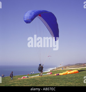 Gleitschirm nach dem Aufblasen seinen dunklen blauen Fallschirm abheben aus Rasen bedeckt Klippen von Torrey Pines San Diego Kalifornien Stockfoto