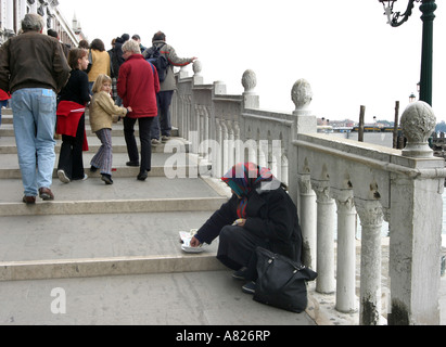 Eine ältere Dame bittet um Geld von Touristen, Venedig, Italien Stockfoto