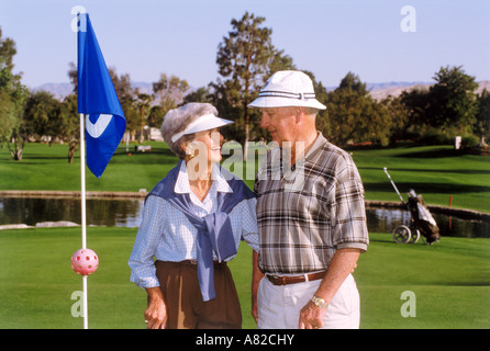 Paar in ihren 70ern teilen gern und romantischen Look beim Golfen in Palm Springs Kalifornien Stockfoto