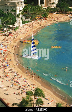 Waikiki Beach in Honolulu mit Katamaranen, Ausleger-Kanu und Sonnenanbeter Stockfoto