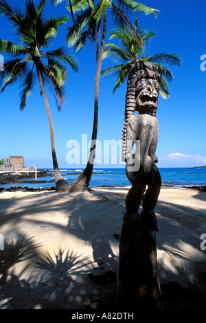 Hölzerne Tiki und Kokospalmen am Puuhonua o Honaunau Stadt der Zuflucht Kona Küste The Big Island Hawaii Stockfoto