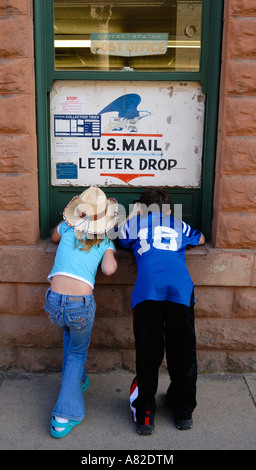 Jungen und Mädchen auf der Suche durch mail-Slots im Kleinstadt-Postamt Stockfoto