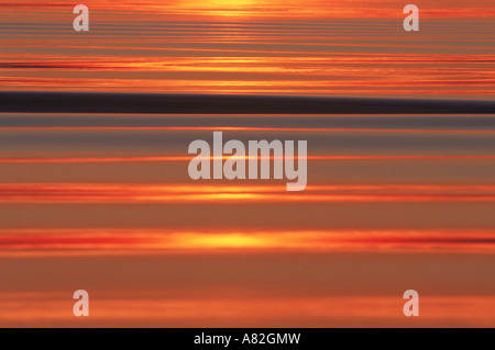 Sonne, Wellen überqueren spiegelglatten Wasser reflektiert Stockfoto