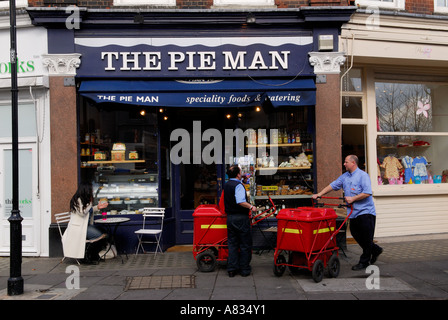 Zwei Briefträger ihre Lieferung Morgen zu tun. London England The Pie Man Shop, Cale Street, "Chelsea Green". HOMER SYKES Stockfoto