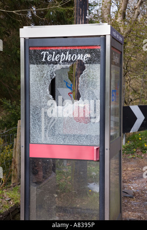 Vandalisierte moderne Telefonbox für den ländlichen Raum mit durchbrochenem Glasfenster mit seitlichem Blick. Wales Großbritannien Stockfoto