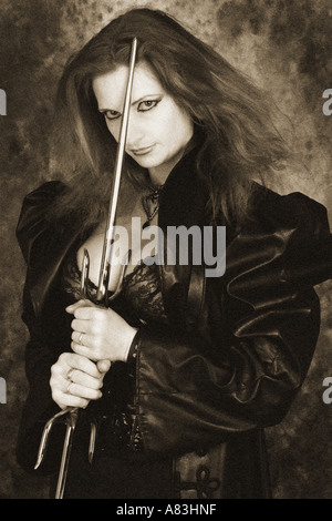 Gothic-Frau trägt einen Spider Halskette Ledermantel und hält zwei Dolche Stockfoto