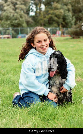 Mädchen mit Cocker Spaniel Hund sitzen auf Rasen Stockfoto