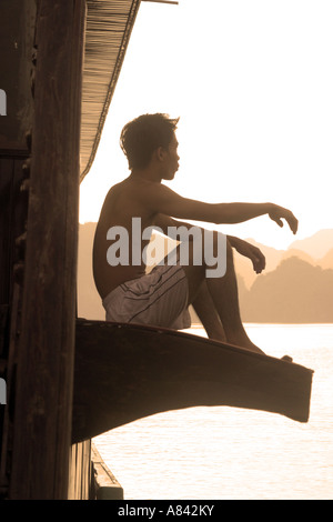 Mann sitzt allein auf einem Boot in der Halong Bucht Vietnam Stockfoto