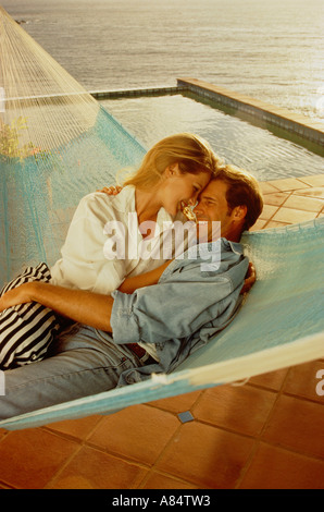 Junges Paar teilen Hängematte auf der Terrasse am Meer. Stockfoto