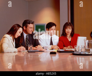 Zwei Männer und zwei Frauen, die am Schreibtisch sitzen. Die Executive Group treffen. Stockfoto