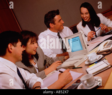 Zwei Männer und zwei Frauen, die am Schreibtisch sitzen. Die Executive Group treffen. Stockfoto