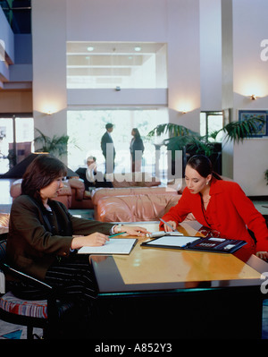 Menschen sitzen und stehen in der Lobby des Hotels. Stockfoto
