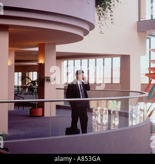 Geschäftsmann, stehend auf Mezzanine Interieur des modernen Bürogebäude und sprechen auf dem Handy "Telefon. Stockfoto
