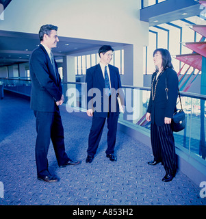 Zwei Männer und eine Frau in der Wirtschaft passt auf Mezzanine in Gebäude stehen. Stockfoto