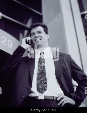 Exekutive Geschäftsmann am Handy vor modernen Stadt Bürogebäude sprechen. Stockfoto