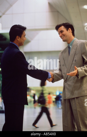Zwei Männer Händeschütteln in Singapur Flughafen terminal Gebäude. Stockfoto