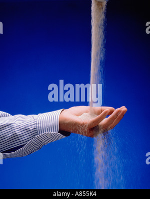 Studio close-up Konzept der Hand des Mannes offen Palm Strom von Sand zu fangen. Stockfoto
