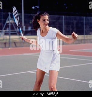 Junge Frau mit dem Tennisspielen auf Hartplatz. Stockfoto
