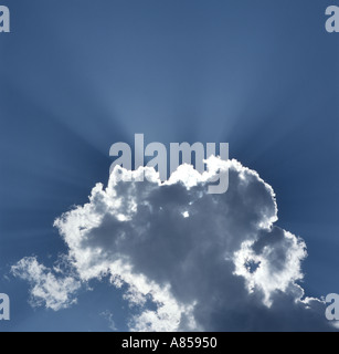 Sunburst hinter Cumulus Wolke am blauen Himmel Stockfoto