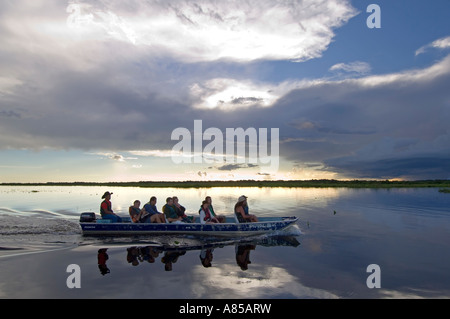 Eine Gruppe von europäischen Touristen eine Bootsfahrt auf dem Pantanal in Brasilien bei Sonnenuntergang zu genießen. Stockfoto