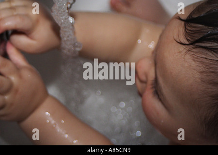 Baby spielt in der Dusche Stockfoto