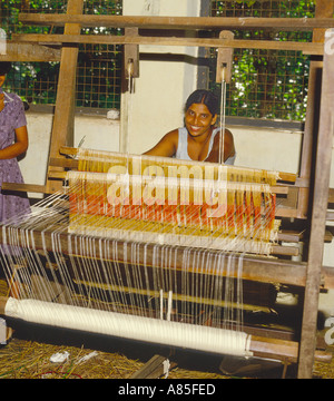 Sri Lanka Mädchen lächelnd in die Kamera, wie sie einen traditionellen alten hölzernen weben arbeitet Webstuhl von hand Sri Lanka Stockfoto