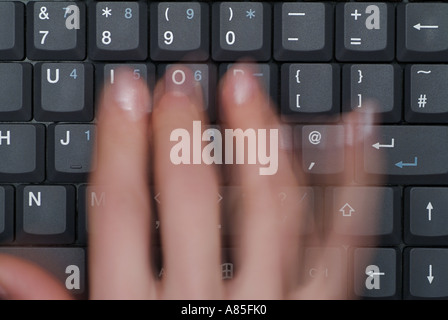 Verschwommen Bewegung ein Womans Finger als sie Typen auf der Tastatur eines mobilen Laptops Stockfoto